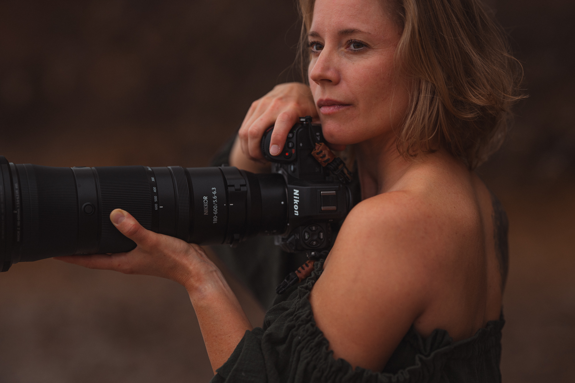 Tina Datz mit Nikon-Kamera und Teleobjektiv — nachdenklicher Blick